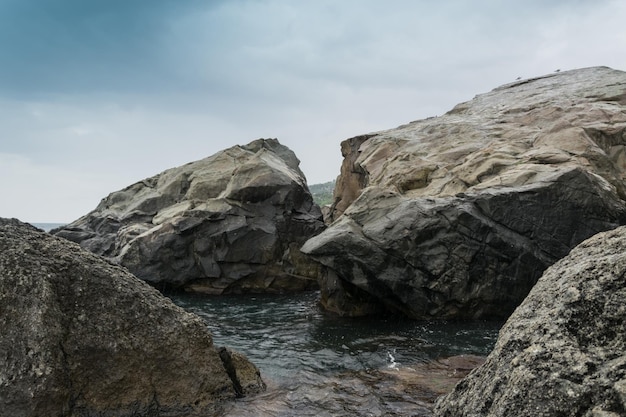 Grote stenen keien aan de kust de oceaan Bewolkt weer op vakantie