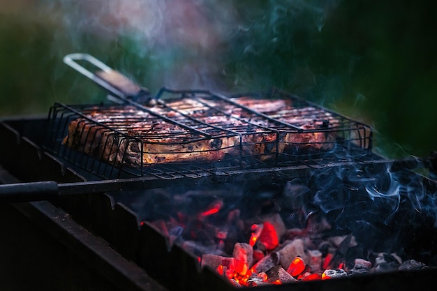 grote stukken sappig barbecuevlees worden buiten geroosterd op een grill boven brandende kolen