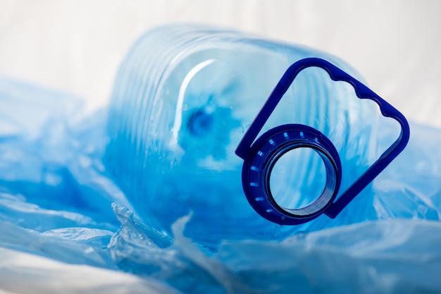 Grote transparante geopende waterstok liggend op dun plastic materiaal en wachtend op recycling