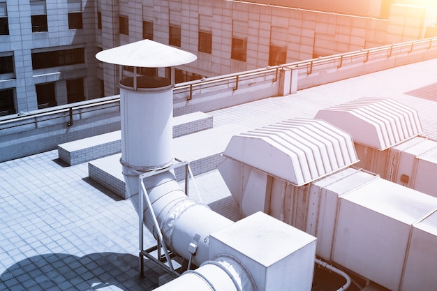 Foto grote ventilatiesysteempijpleiding op het dak van het gebouw