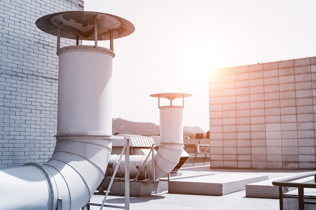 Foto grote ventilatiesysteempijpleiding op het dak van het gebouw