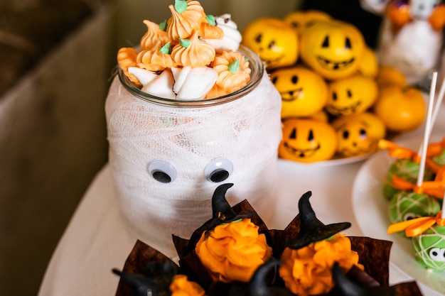 Grote versierde pot met pompoen marshmallows op de reep voor de viering van Halloween