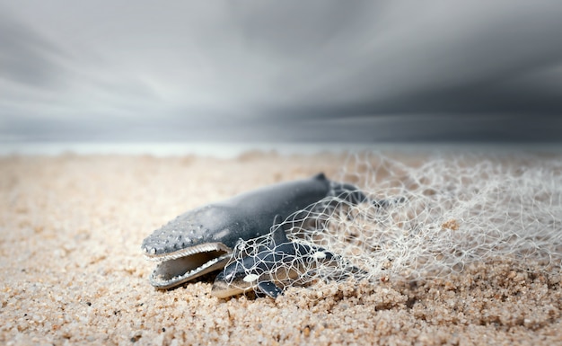 Grote walvis en baby dolfijn verstrikt in een visnet. Environmentalism en plastic bewustzijn concept