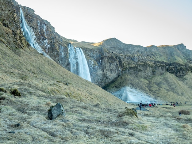 Grote waterval bij Seljalandsfoss-waterval met grote sneeuw met kleine oplopende fontein IJsland