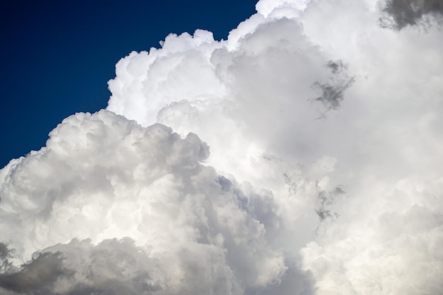 Grote witte cumulus onweerswolken tegen een blauwe lucht voor regen