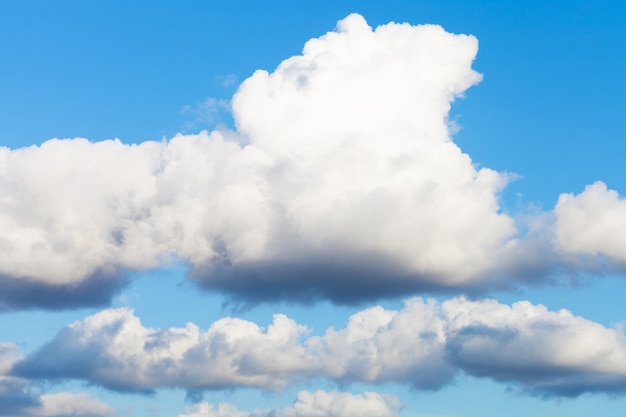 Grote witte en grijze wolken in de blauwe lucht in de avond