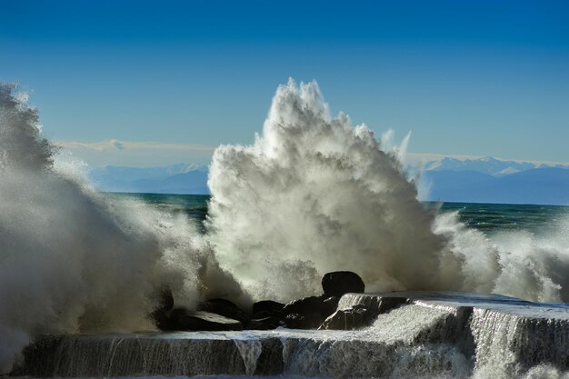 Foto grote witte golven van de middellandse zee beuken tegen de golfbreker