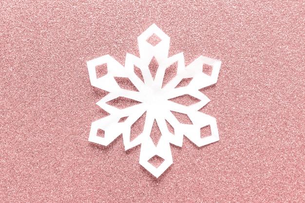 Grote witte papieren sneeuwvlok op roze glitter achtergrondkleur