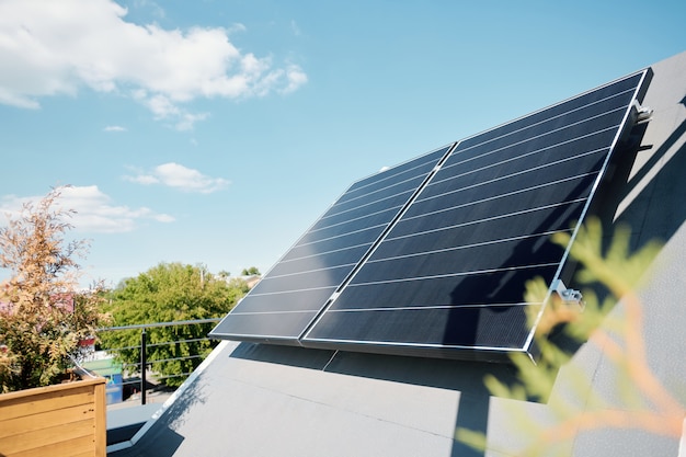 Grote zonnepanelen op het dak van een modern comfortabel huis of cottage in een natuurlijke omgeving