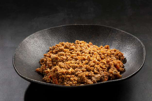 Ground beef in dark plate on the table