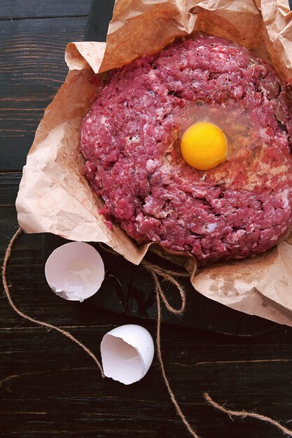 Ground beef in a paper bag with a raw egg