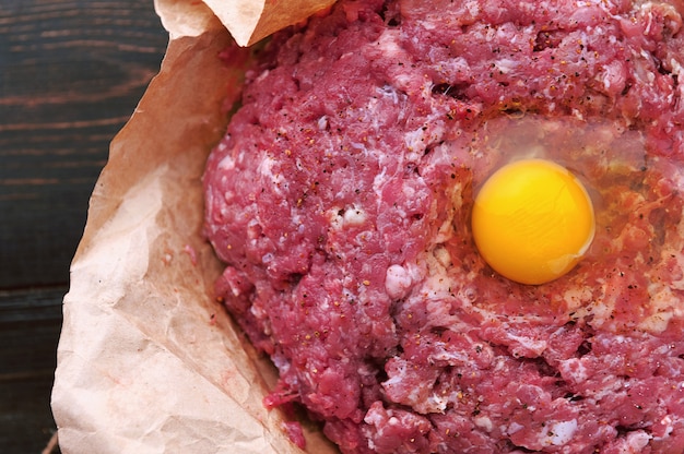 Ground beef in a paper bag with a raw egg