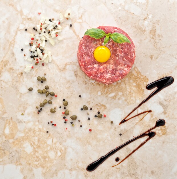 Ground beef and raw egg with herbs and spices