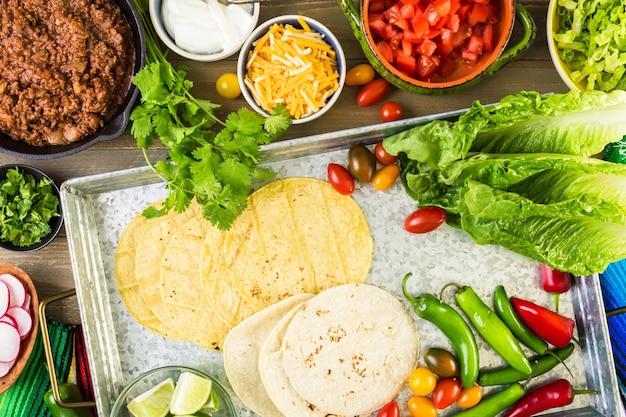 Ground beef tacos with romaine lettuce, diced tomatoes, radished, and shredded cheddar cheese.