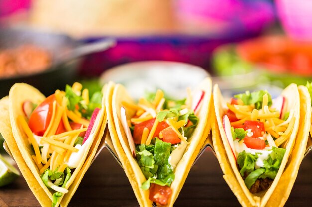 Ground beef tacos with romaine lettuce, diced tomatoes, radished, and shredded cheddar cheese.