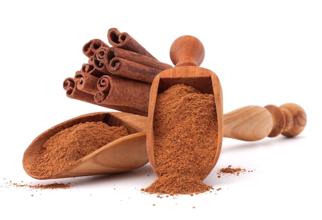 Ground cinnamon spice powder in wooden spoon isolated on white background cutout