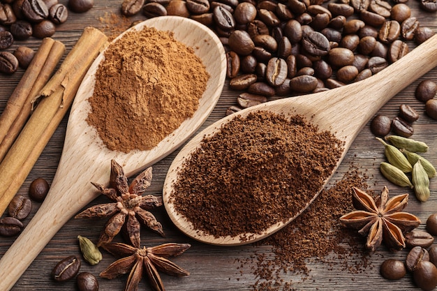 Ground coffee and cinnamon in spoon next to coffee beans