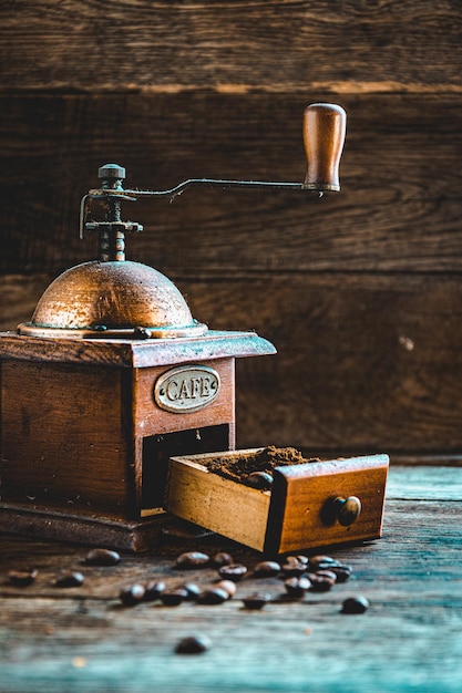 Ground coffee in a manual coffee grinder on a wooden table. Making homemade coffee.