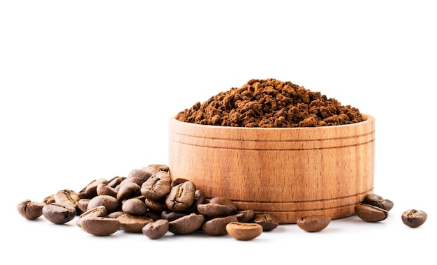 Ground coffee in a wooden plate and coffee beans  isolated.