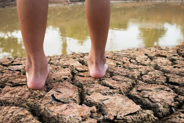 Фото Земля сухая на детской ноге концепции засухи.