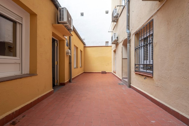 Ground floor house with several windows and patio with clay floors