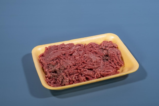 Ground red meat in yellow foam board