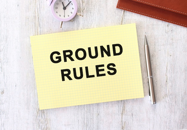 GROUND RULES text written in a notebook lying on a wooden work table. Business concept.