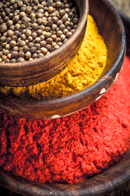 Ground spices in bowls. On a wooden background.