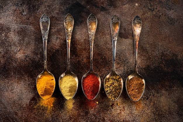 Ground Spices and herbs in old spoons