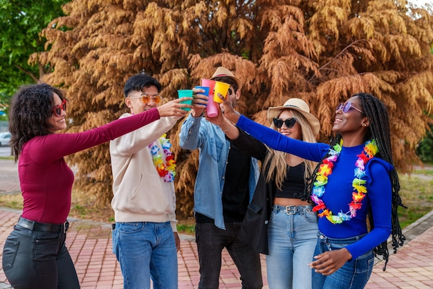 Group of 5 Friends Celebrating with Colorful Drinks and Flower Necklaces