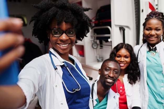 Gruppo di medici paramedici africani dell'equipaggio di emergenza dell'ambulanza che prendono selfie sul telefono