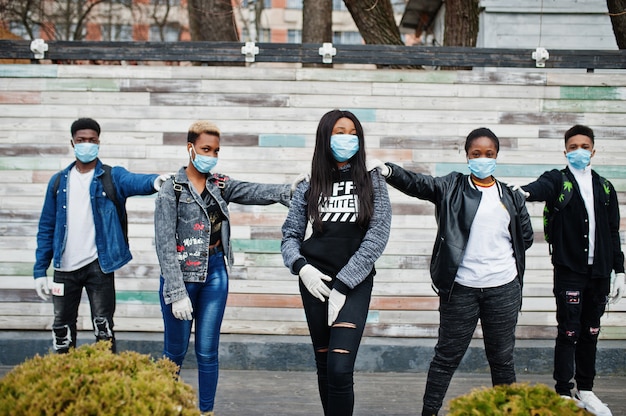 Group of african teenagers friends wearing medical masks protect from infections and diseases coronavirus virus quarantine.