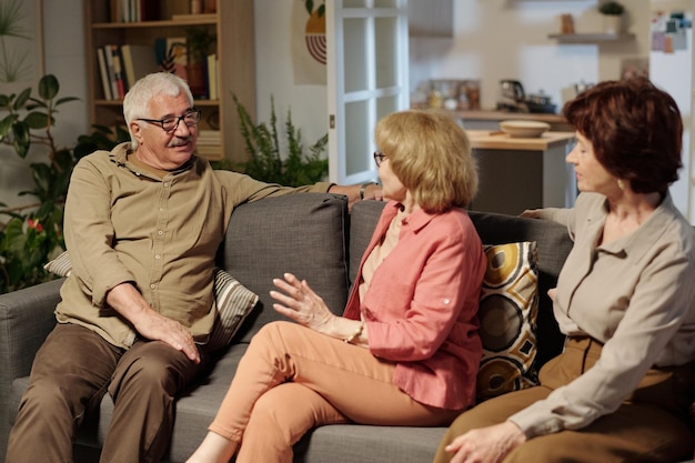 Group of aged friendly people in casualwear discussing latest news