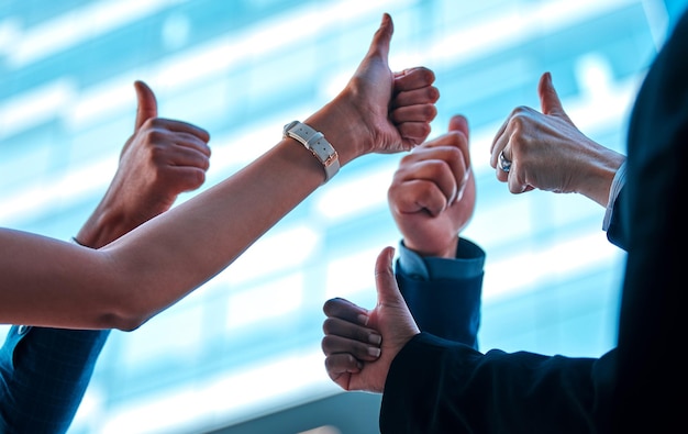 Photo a group in agreement arguably the most powerful force shot of a group of young businesspeople giving each other a thumbs up against an urban background