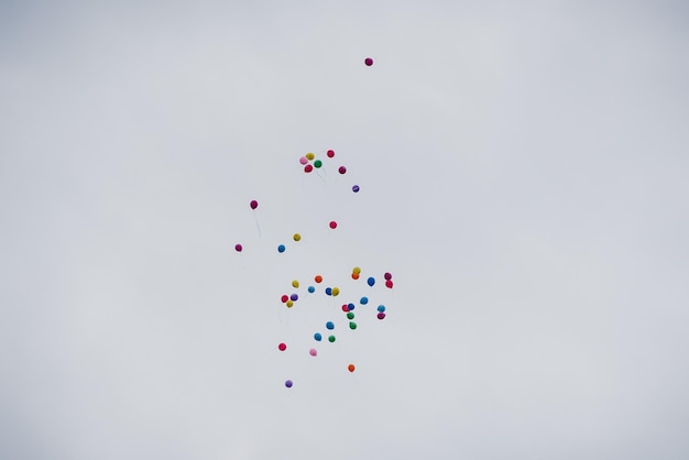 Group of air colored gel balls flying against sky