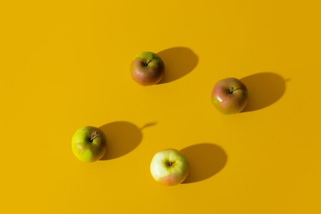 Группа яблок на желтой поверхности