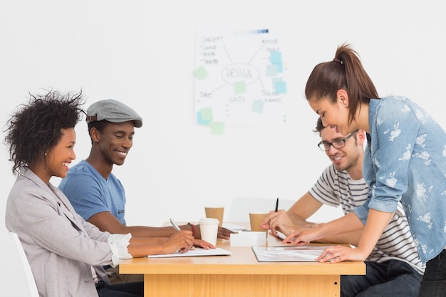 Group of artists in discussion at desk at office