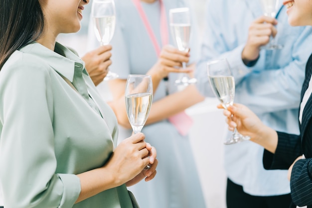 Gli uomini d'affari asiatici del gruppo stanno facendo un brindisi insieme e chiacchierando a una festa aziendale