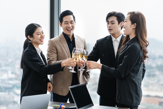 group of Asian business people holding glasses of wine to celebrate new year