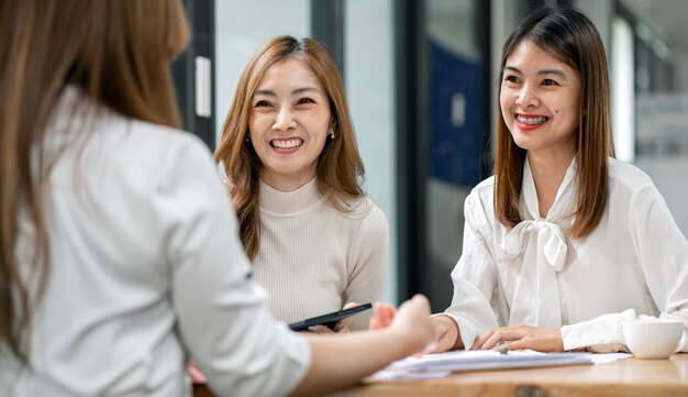 현대 사무실에서 테이블 주위에 창의적인 회의에서 협력하는 아시아 경제인 그룹