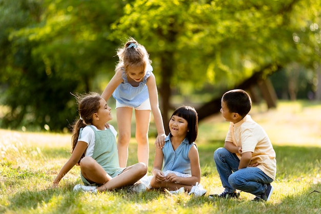 Gruppo di bambini asiatici e caucasici che si divertono nel parco