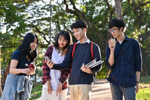 アジアの大学生のグループは、授業を終えた後、キャンパスの公園で一緒に散歩を楽しんでいます