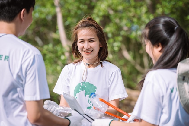 Foto gruppo di persone diverse asiatiche volontario per la conservazione dell'ambiente di lavoro di squadrail volontario aiuta a raccogliere rifiuti di plastica e schiuma nell'area del parcogiornata mondiale dell'ambiente di volontariato