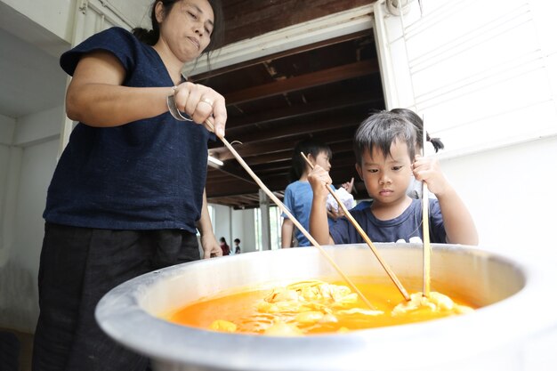 自宅で絞り染めの生地を作ることを学ぶアジアの子供たちのグループ。