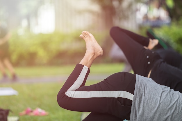 Gruppo di donna asiatica che fa yoga o esercizio nel parco