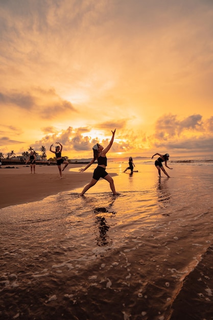 A group of Asian women dancing together and full of joy on the beach