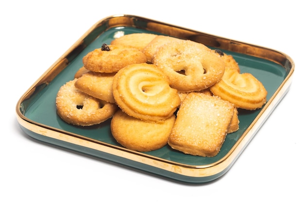 Group of assorted of danish butter cookies in a green plate isolated on white background