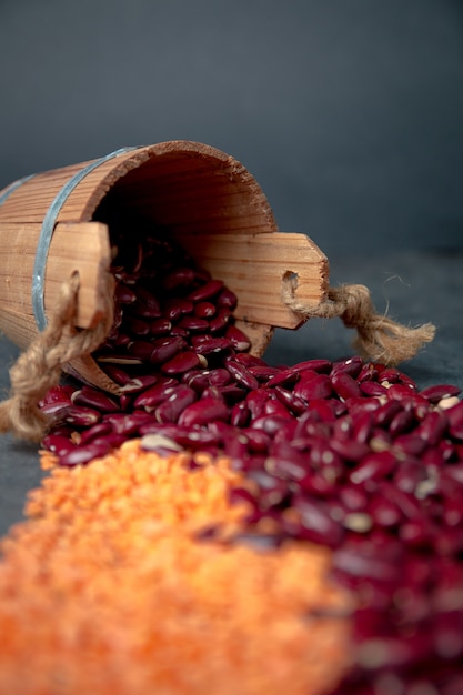 Group of beans and  lentils  wooden cup on black 