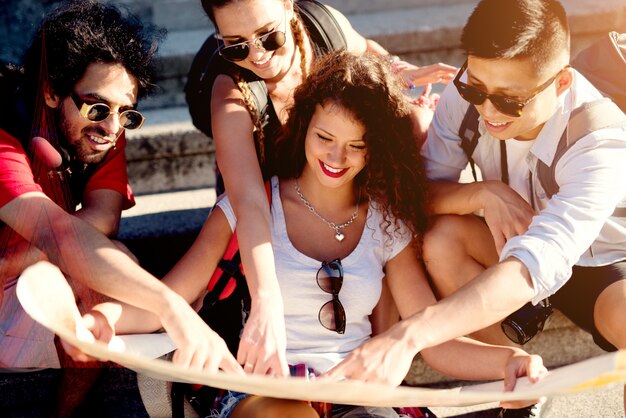 Group of beautiful best friends are together choosing a new destination on the map.