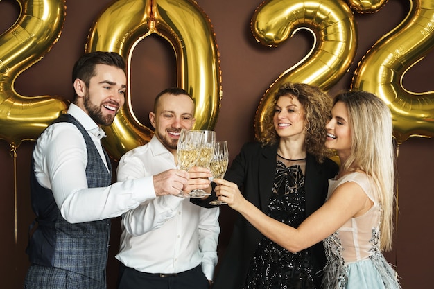 2022년 새해를 축하하고 스파클링 와인을 마시는 아름다운 잘 차려입은 파티 사람들